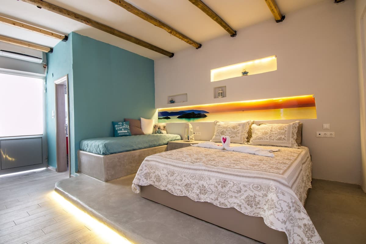 Ein modernes Schlafzimmer mit einem großen Bett, einem Nachttisch, einer Ablagefläche und einem eingebauten Regal über dem Bett.