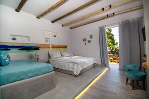 Un dormitorio con dos camas, techo de madera, vistas al exterior y una pequeña mesa con una silla.