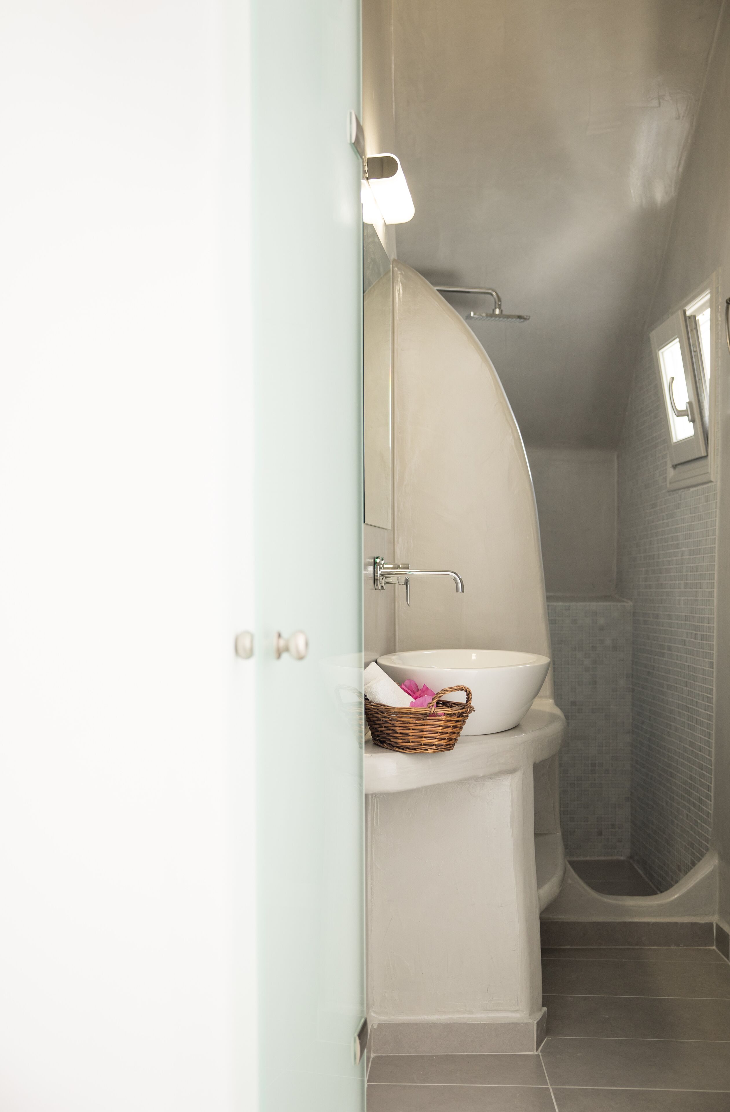A bathroom with a white sink, a mirror, and a shower area.