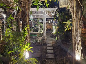 A pathway leading to a traditional building with a thatched roof, surrounded by lush greenery and stone steps. - Santhiku Hotel & SPA (Banjar)
