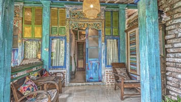 A traditional room with wooden furniture, a patterned bench, and a blue door.