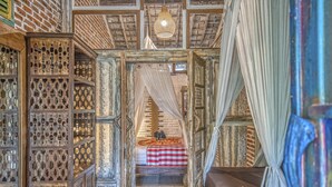 A traditional room with a bed, a wooden cabinet, and a hanging light fixture. - Santhiku Hotel & SPA (Banjar)