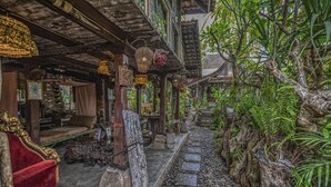 A traditional wooden building with a stone pathway, wooden furniture, and hanging lanterns. - Santhiku Hotel & SPA (Banjar)