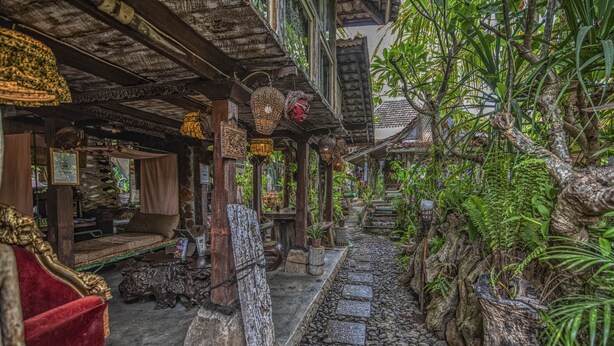 A traditional wooden building with a stone pathway, wooden furniture, and hanging lanterns. - Santhiku Hotel & SPA (Banjar)