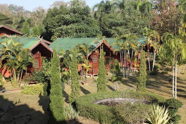 Un conjunto de edificios de estilo tradicional con techos verdes, rodeados de exuberante vegetación tropical.