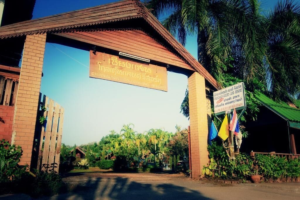 A wooden archway with a sign indicating a resort.