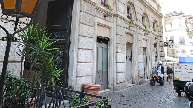 Un edificio histórico con ventanas de arco y una calle empedrada.