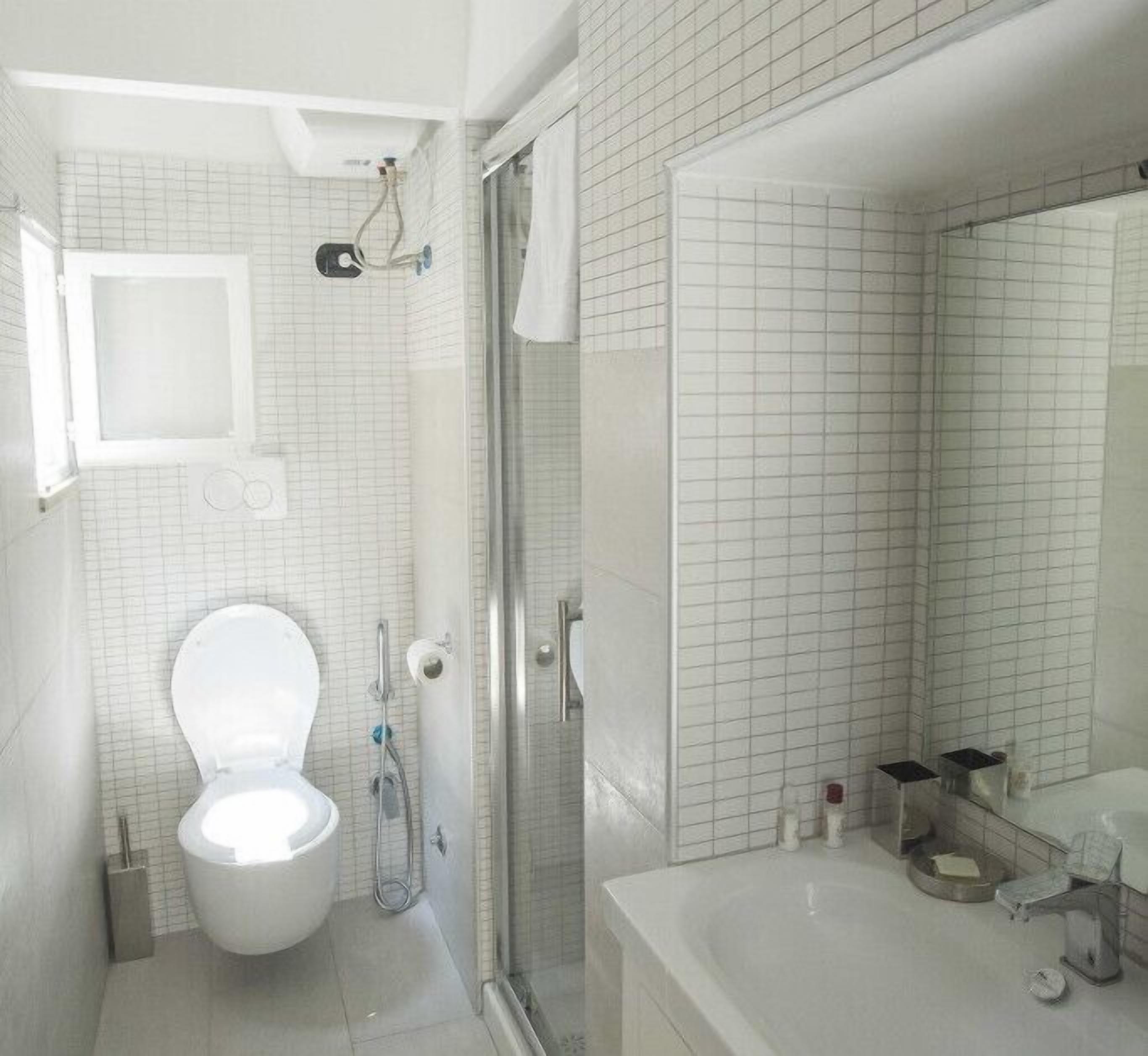 Une salle de bain moderne équipée de toilettes, d’une douche et d’un lavabo.