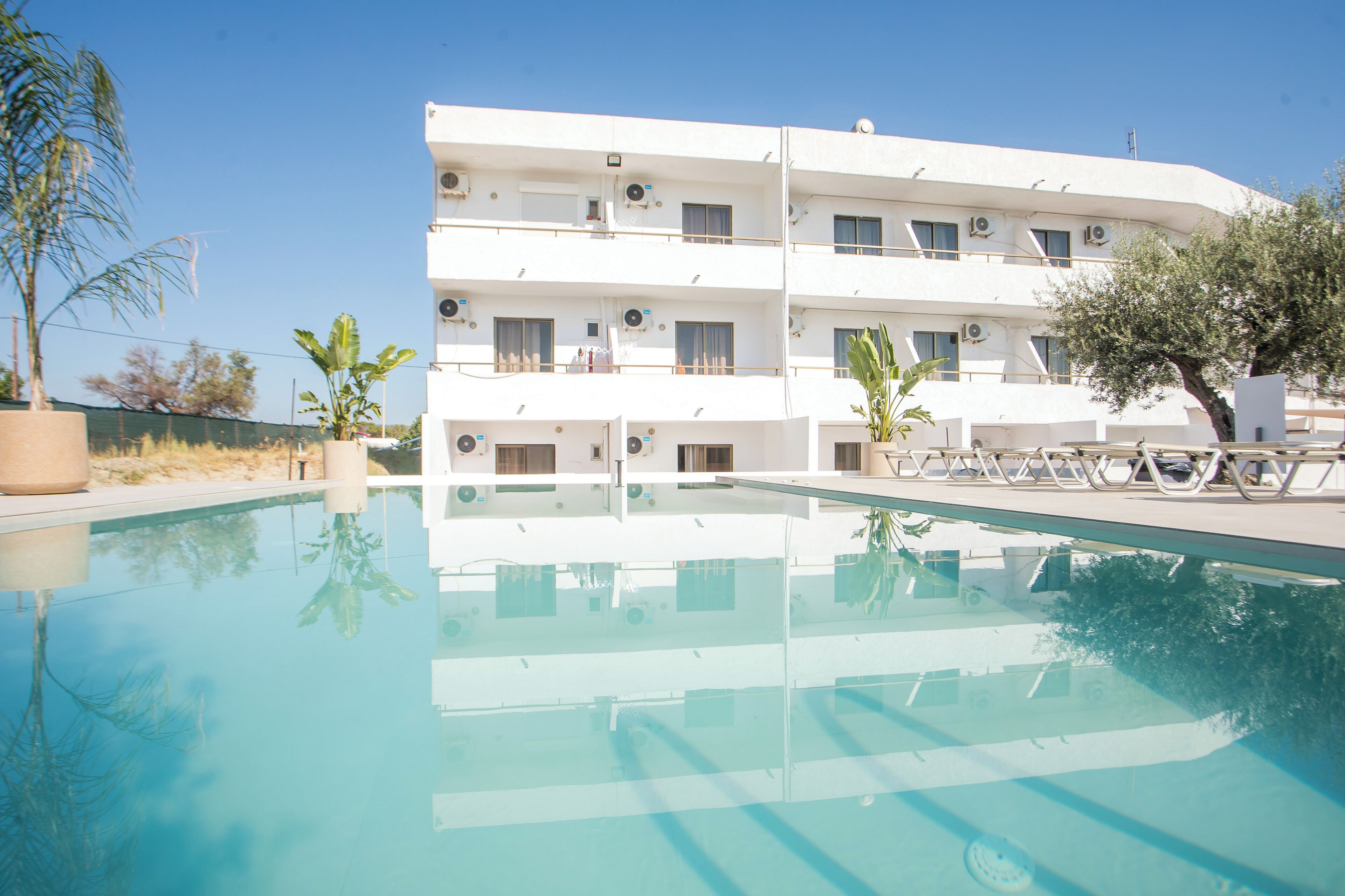 Een hotel met meerdere verdiepingen, een zwembad, balkons en airconditioning.