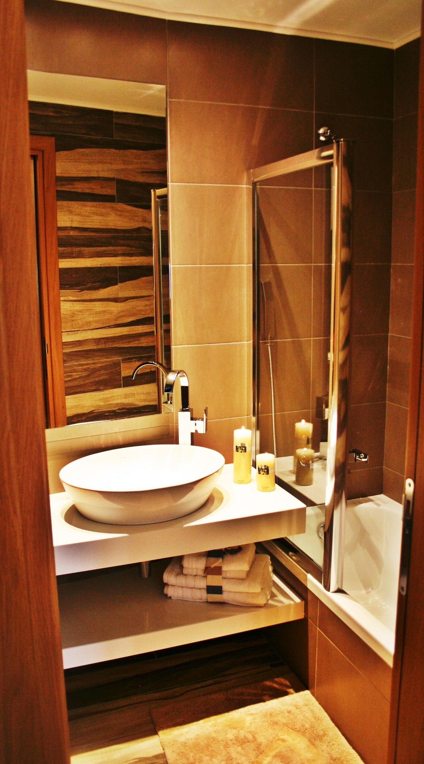Un baño moderno con un espejo grande, un lavamanos y una ducha.