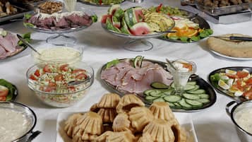 En buffet med forskellige retter, herunder salater, kød og grøntsager.