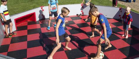 A group of children playing on a checkered floor with a red and black pattern.