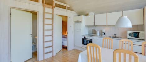 A compact kitchen with white cabinets, a microwave, and a coffee maker.