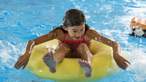 A person floating on a yellow inner tube in a pool. - Skærbækcentret (Skaerbaek)