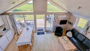 A modern RV interior with a dining area, kitchen, and living space. - Skærbækcentret (Skaerbaek)