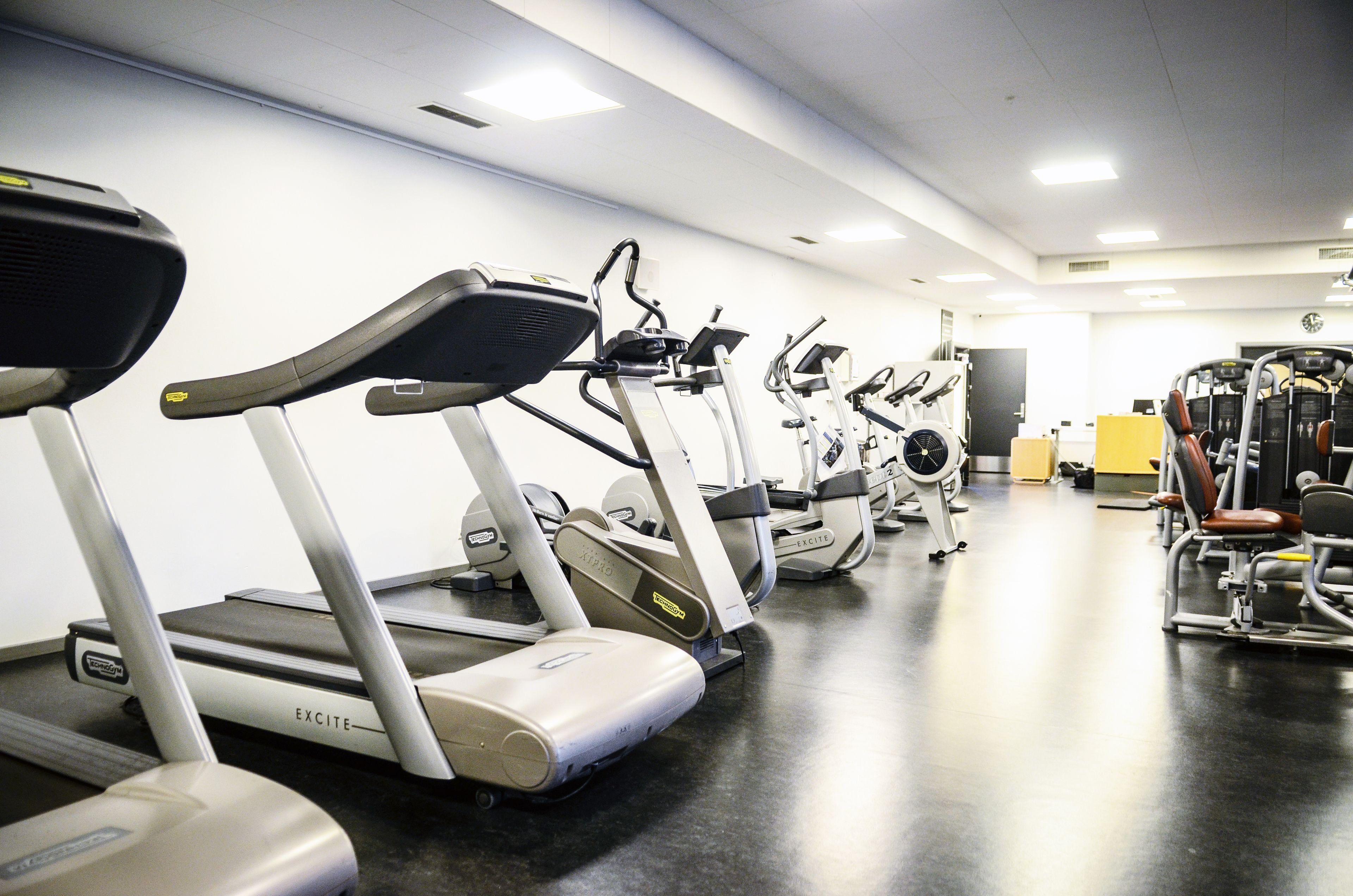 A gym with multiple treadmills and exercise machines.