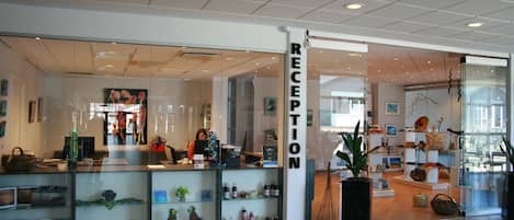 A reception area with a glass display case containing various items and a reception desk.