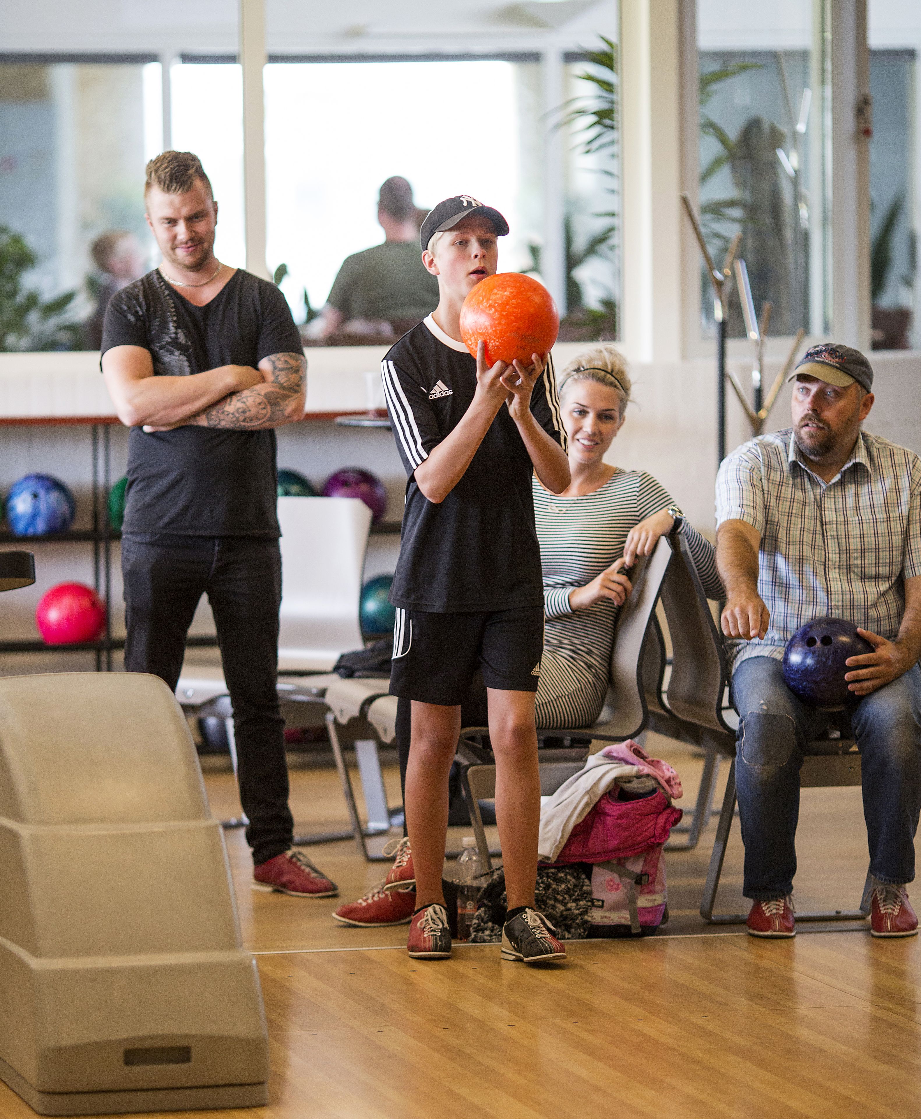 A bowling alley with people playing and watching.