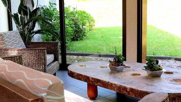 Relax and socialize in this serene outdoor seating area with a round table and wicker furniture.