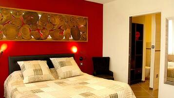 Ein Schlafzimmer mit einem Bett, einer roten Akzentwand und einer Wanddekoration.