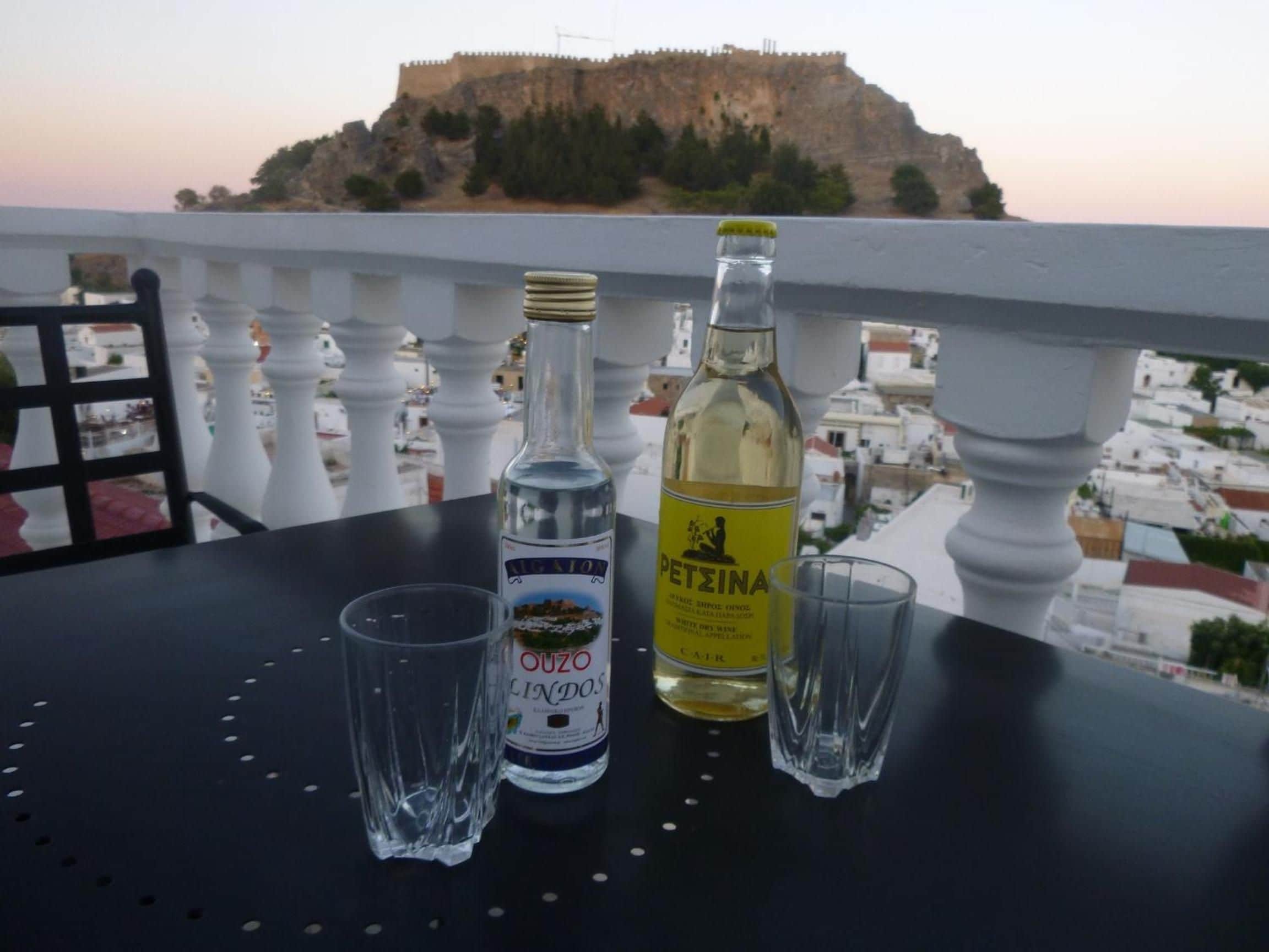 Ett bord med två flaskor alkohol och två glas, med utsikt över en befäst kulle.