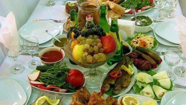 A long dining table set with various dishes, including seafood, salads, and bread, suggesting a buffet-style meal. - Hotel Kutaisi Globus (Kutaisi)