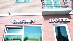 A hotel with a sign reading "HOTEL" and "Kutaisi" on the windows. - Hotel Kutaisi Globus (Kutaisi)