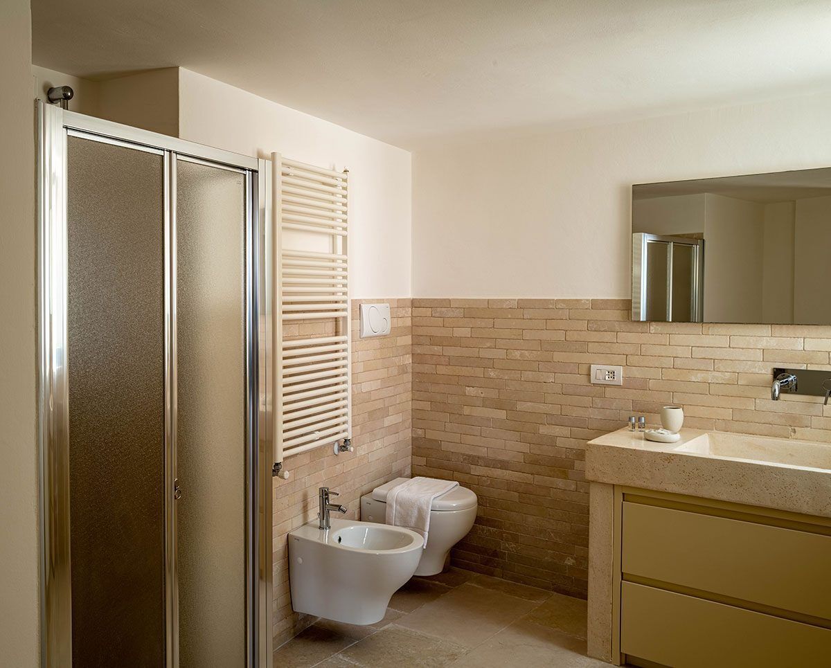 Un baño con ducha, inodoro, bidé y lavamanos con espejo.