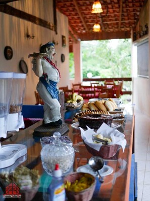 Una mesa de buffet con diversos alimentos y una estatua de una persona.