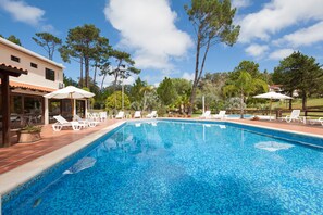 Una piscina al aire libre, sombrillas