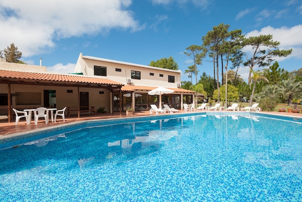 Una piscina al aire libre, sombrillas