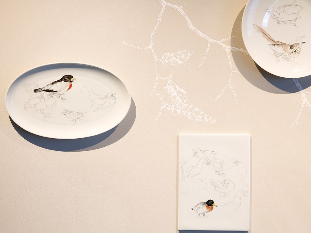 Three ceramic plates with bird illustrations on a wall.