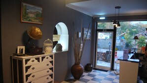 A hotel lobby with a checkered floor, a white cabinet with drawers, a large vase with sticks, a gramophone, and a sign that reads "HOTEL AVISTA". - Hotel Boavista - Vintage House (Idanha-a-Nova)