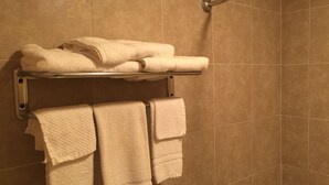 Un baño con un perchero que sostiene toallas dobladas y una toalla colgando.