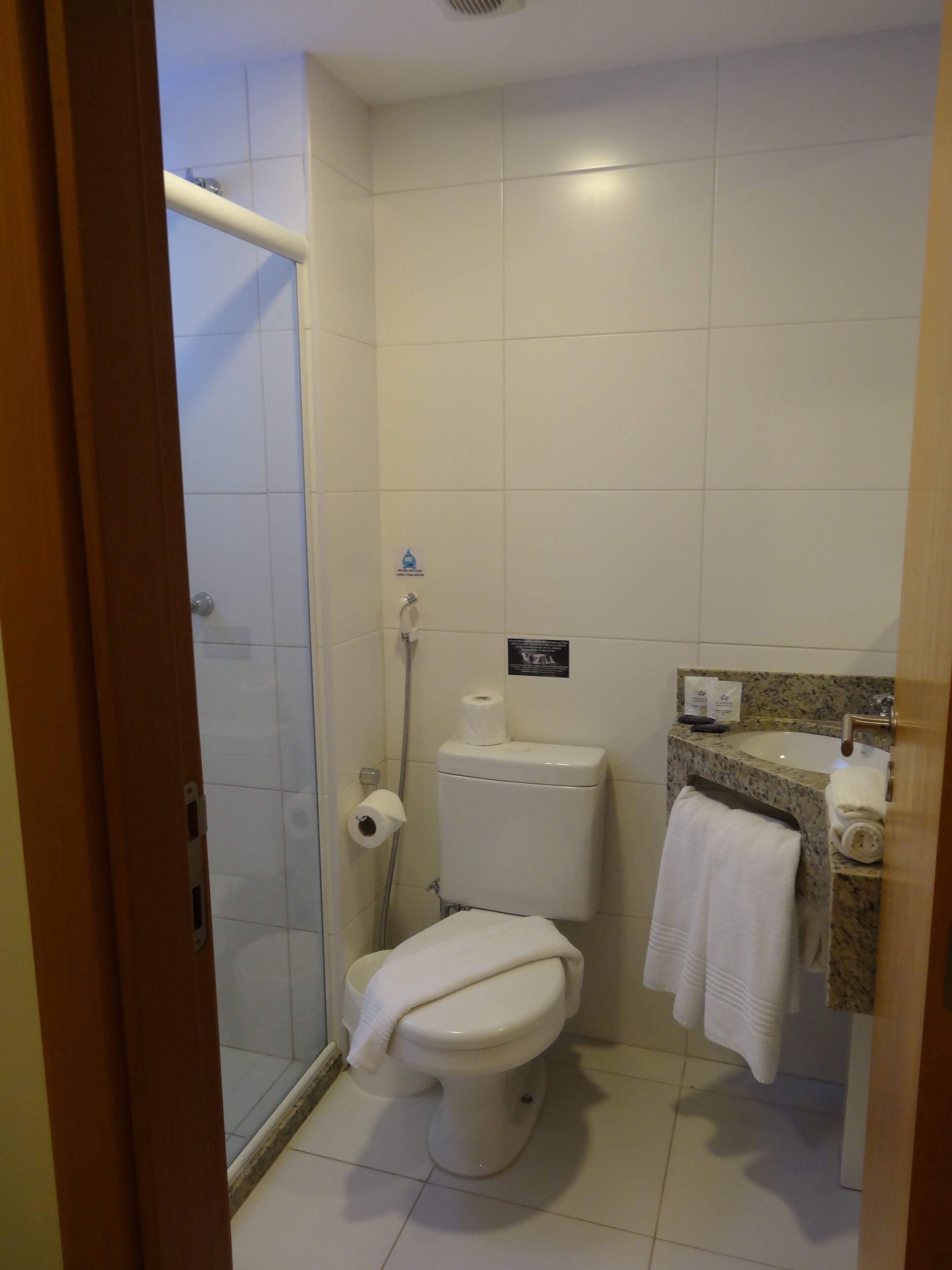 A bathroom with a toilet, shower, and sink.