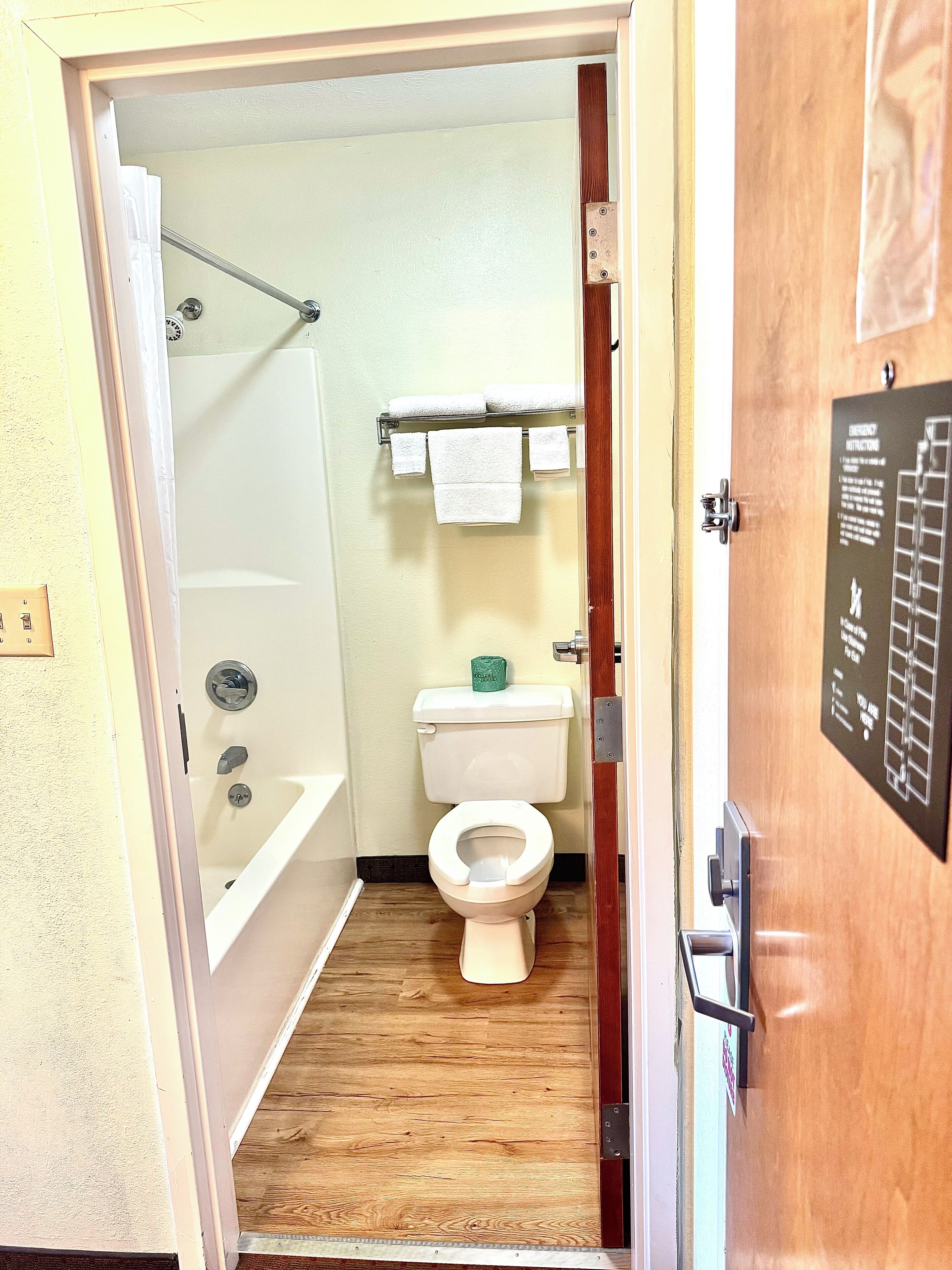 A bathroom with a toilet, a shower, and a towel rack.
