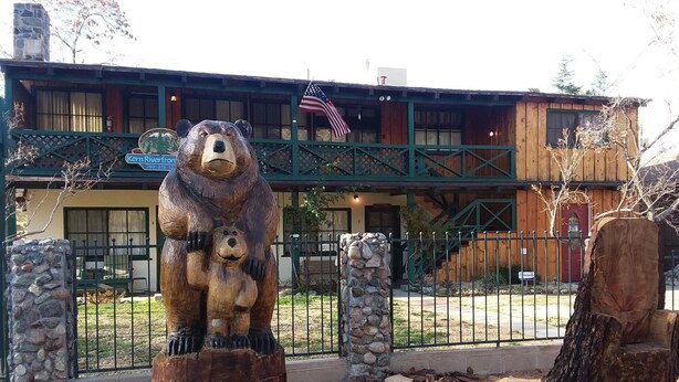 A wooden building with a bear statue in front. - Kern Riverfront Lodge (Kernville)