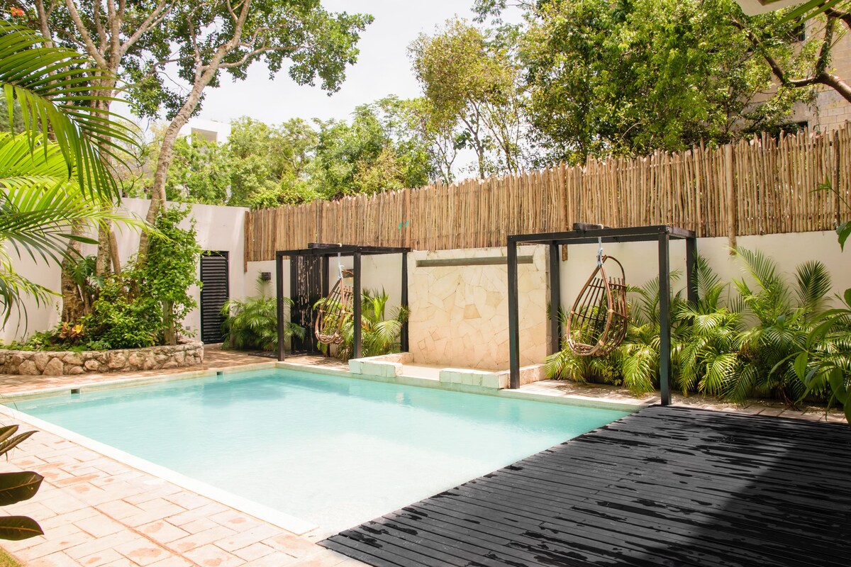 Che Tulum Hostel pool area with rattan swings