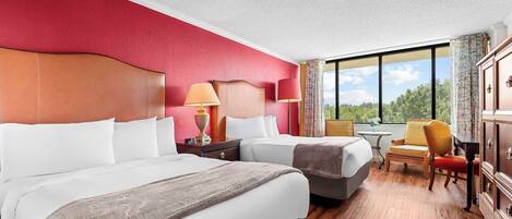 A hotel room with two beds, a desk, a chair, and a wardrobe.