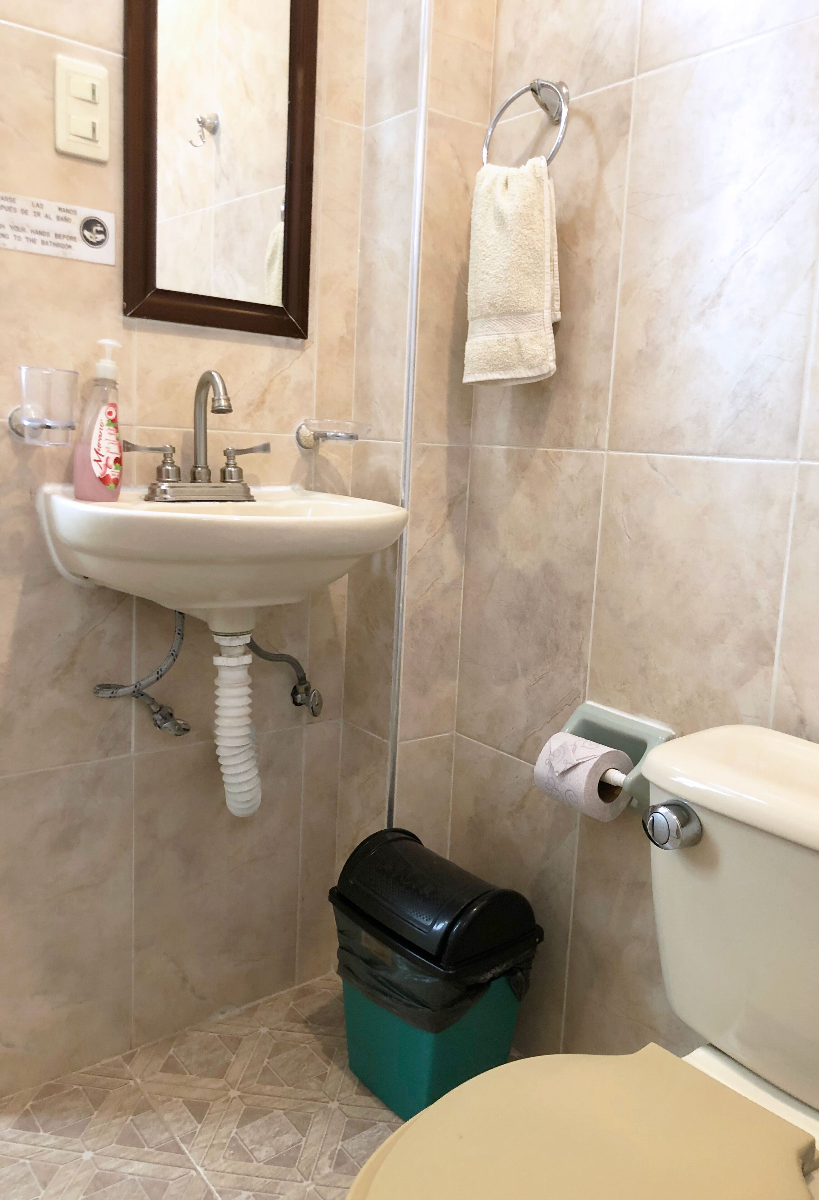 Ein Badezimmer mit Waschbecken, Toilette und Mülleimer.