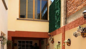 A narrow alleyway with a tiled floor, a door with glass panels, and a window above. - Hotel Jatziri Teotihuacan (Teotihuacan)