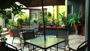 An outdoor patio area with tables and chairs, surrounded by potted plants and flowers. - Hotel Jatziri Teotihuacan (Teotihuacan)