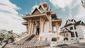 A traditional Thai temple with ornate architecture, including a multi-tiered roof and golden decorations. - Seasons Riverside Hotel (Vientiane)