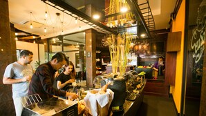 A restaurant with a buffet setup, including a hot pot and various food items. - Seasons Riverside Hotel (Vientiane)