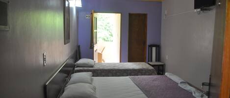 Een hotelkamer met twee bedden, een televisie en een airconditioning.
