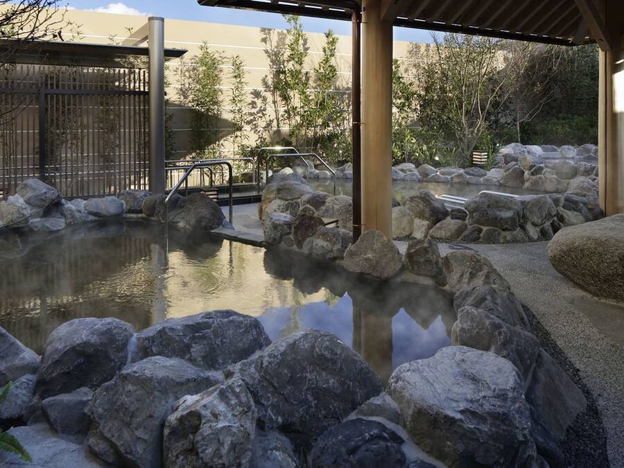 A hot spring area with large rocks and a wooden deck.