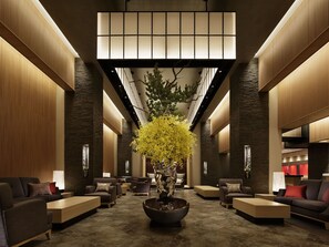 A spacious lobby with a central seating area, a large potted plant, and a modern ceiling design. - Kobe Minato Onsen Ren - Adult Only (Kobe)