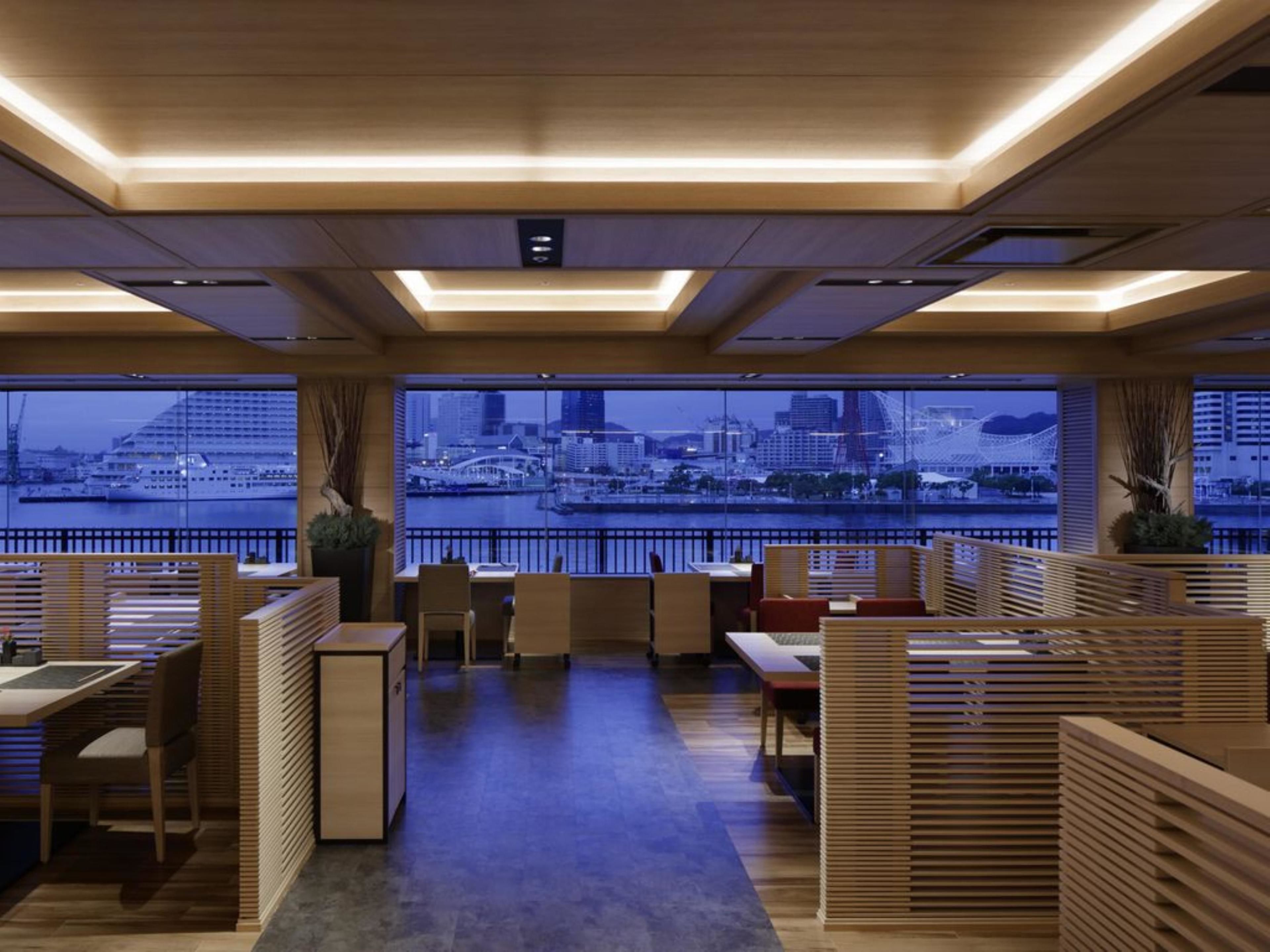 A modern interior with wooden partitions, a view of a cityscape, and a large window.
