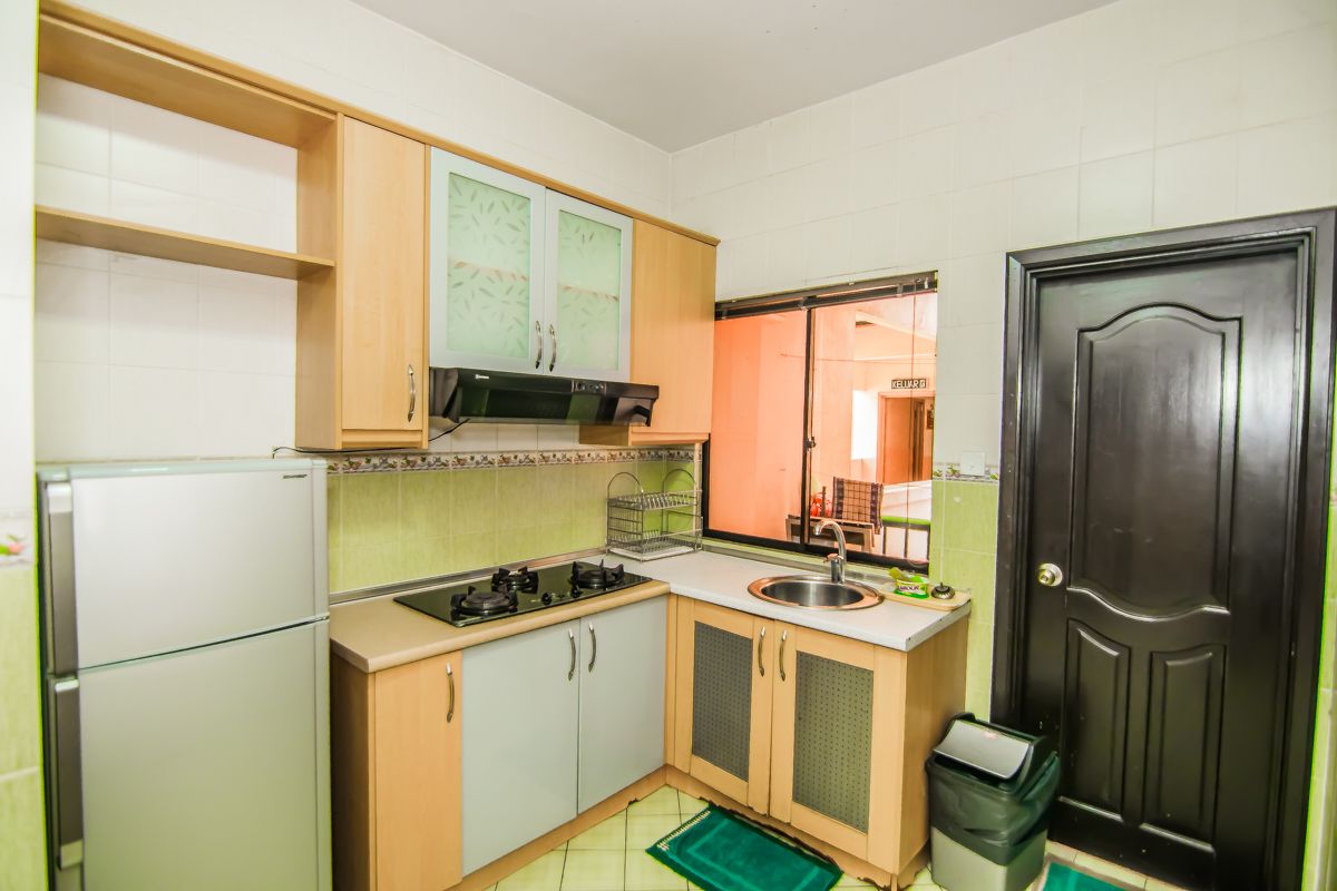 Cocina compacta con refrigerador, estufa, pileta y alacenas.