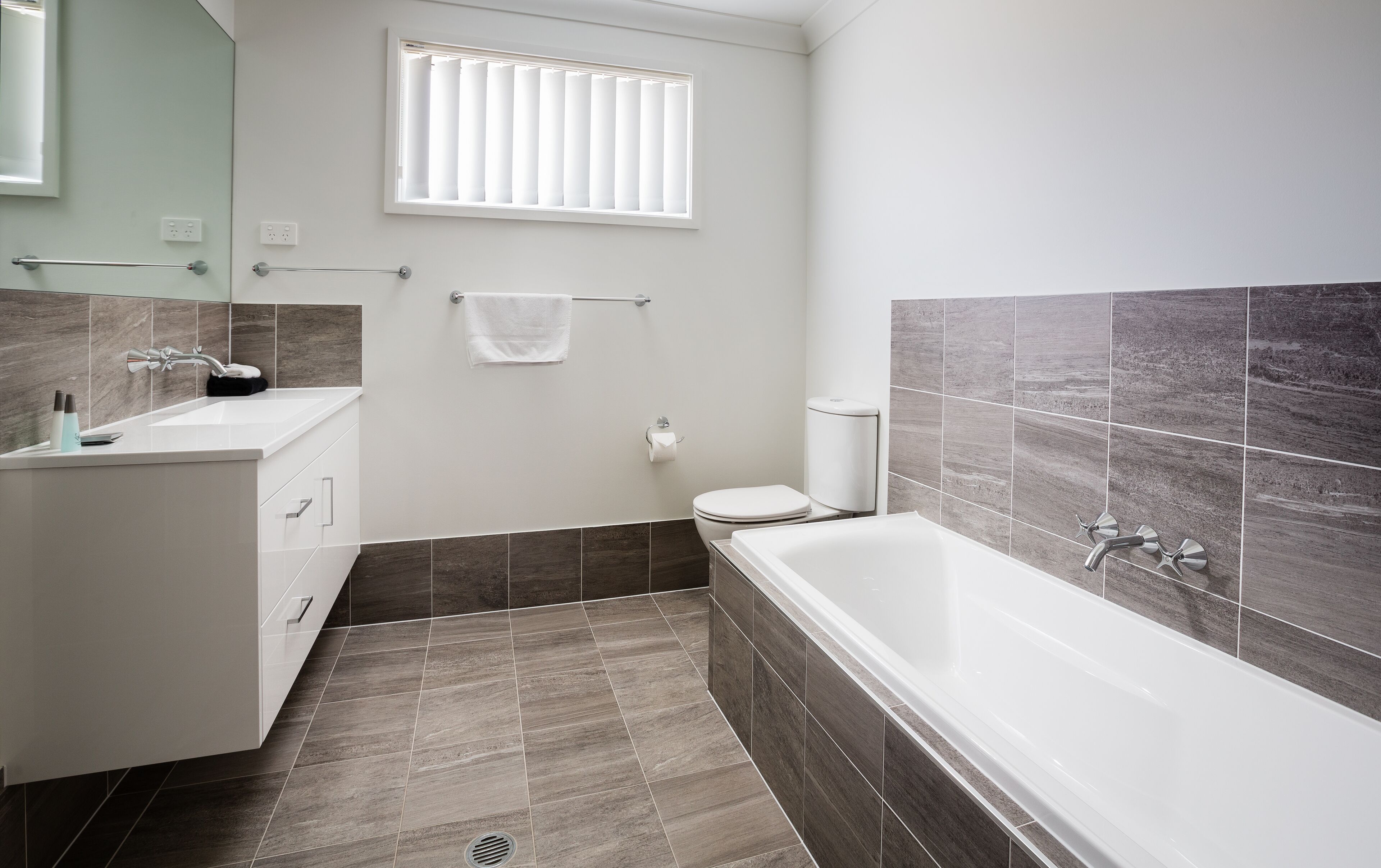 Un baño moderno con bañera, inodoro y lavamanos.